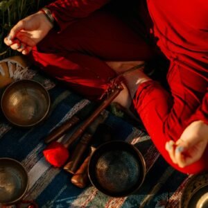 A person meditating outdoors with Tibetan singing bowls, creating a peaceful atmosphere.
